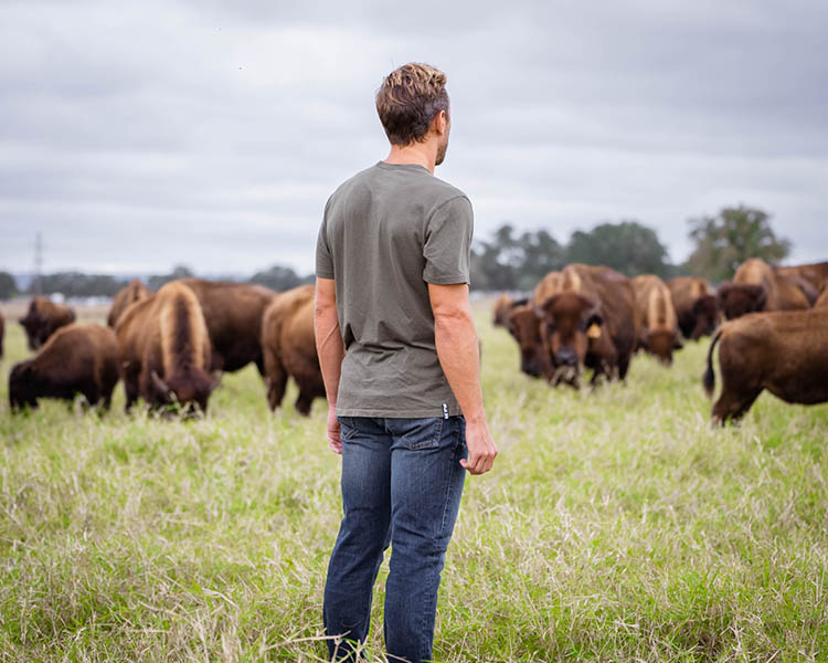 Paul in a field of Bison